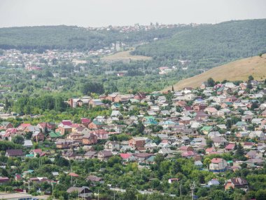 Zhigulevsk, Samara bölgesi, Rusya - 18 Temmuz 2020: Zhigulevsk şehri dağdan görülüyor. Kulübeleri ve küçük ahşap evleri olan küçük bir Rus kasabasının manzarası.