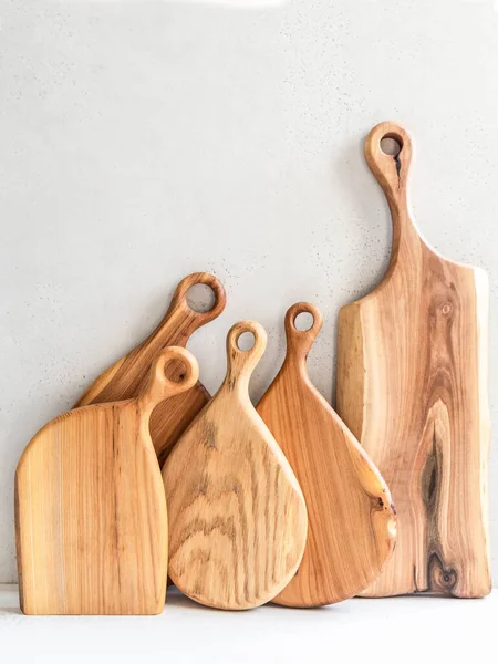 Set of wooden cutting boards layout against gray wall. Minimal kitchen concept. copy space