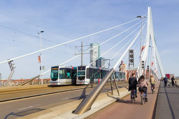 Rotterdam, Hollanda - 7 Nisan 2018; Maas nehri Ret ile geçiş Rotterdam Erasmus Köprüsü üzerinde bisiklet sürme insanlar arka planda tramvay