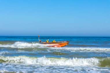 Kijkduin, Lahey, Hollanda - 30 Haziran 2018: kurtarma personel hızlı şişme rijit gövde tekne içinde sörf