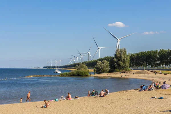 Goeree overflakkee, Hollanda - 14 Temmuz 2018: yaz günü sürdürülebilir enerji ile Hollandalı plaj üzerinde kişi ile Rüzgar türbinleri içinde Bankamatik