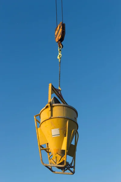 high crane concrete machine for spreading cement hoisted at building site on blue sky background