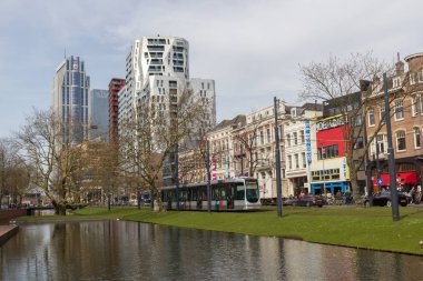Rotterdam, Hollanda - 7 Nisan 2018: tramvay, kanal, köprü ve ön planda yeşil alan üzerine düşünceler ile Rotterdam şehir merkezinin eski ve Modern architecure