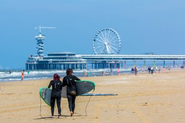scheveningen, Hollanda - 27 Haziran 2018: Plajlı scheveningen iskelesi ve sörf tahtalı gençler