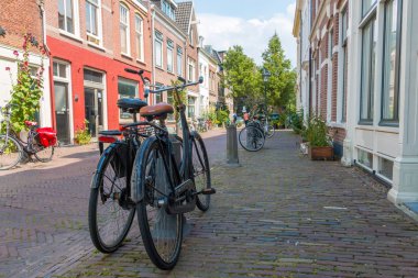 Haarlem, Hollanda - 19 Temmuz 2019: Tarihi Hollanda mimarisi ve ön planda küçük evler ve bisikletler ile Haarlem şehir merkezinde hoş sakin sokak