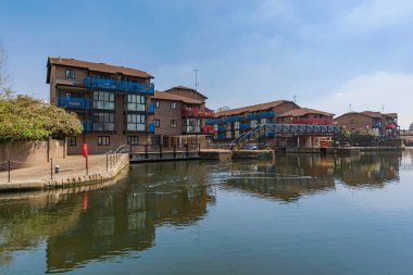 LONDON, UNITED KINGDOM - APRIL 20: View of old riverside apartment buildings in Blackwall Basin near Canary Wharf on April 20, 2018 in London clipart