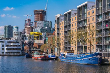 London, Büyük Britanya - 20 Nisan: Modern nehir şehir binaları ve Canary Wharf finans bölgesine 20 Nisan 2018 tarihinde Londra'da yakınındaki Güney Quay içinde tekneler
