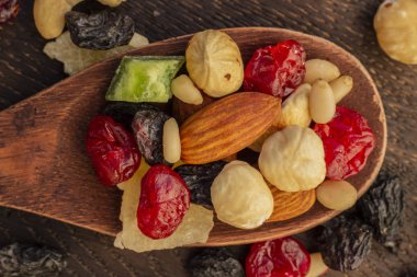 Tahta bir kaşık üzerinde fındık ve kurutulmuş meyve çeşitleri