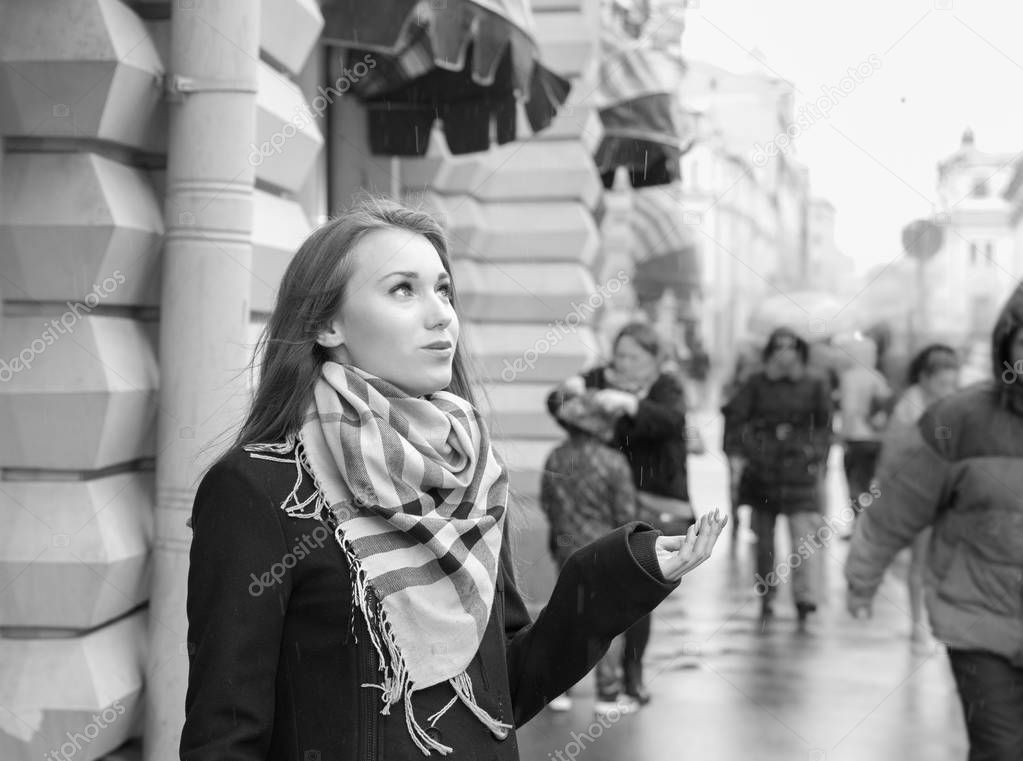 Long hair woman in red dress crazy dancing in the rain at the middle of city square, turning around, she is smiling and enjoying warm weather summer rainy drops