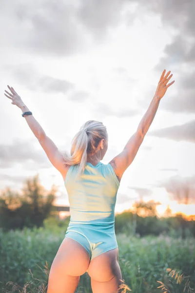 Vista posterior de la hermosa mujer deportiva sexy en ropa deportiva con estilo de pie en el puente. Chica atractiva y segura de fitness con el culo perfecto y las caderas posando al aire libre. Mujer con sexy delgado botín, culo — Foto de Stock