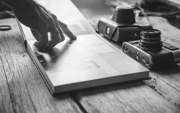 El Mano el hombre que sostiene el álbum de fotos familiar sobre el fondo de la mesa de madera —  Fotos de Stock