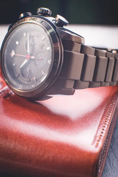Vintage watch on a brown leather wallet. Classic Wristwatch. (Vintage Style Color Process)