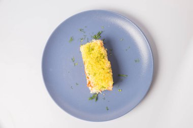Mimosa salatası. Beyaz arkaplanda bir plaka içinde