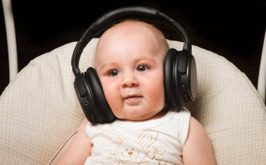 Kulaklıkla gülümseyen bebek.