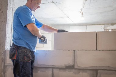 Bina yenileme çalışmaları, duvarları yenilemek için inşaat işçilerinin yaptığı yenilemeleri gösteriyor..