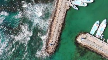 Güneşli bir yaz gününde deniz üzerindeki hava aracı ve dalgakıran manzarası. Ayia Napa, Kıbrıs, 4K