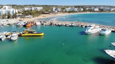 Güneşli bir yaz gününde yat ve teknelerle marina üzerinde İHA uçuşu. Seaview yukarıdan. Ayia Napa, Kıbrıs, 4K