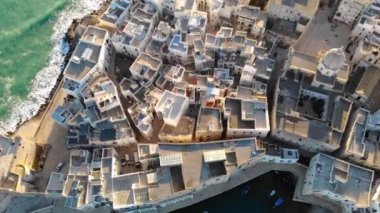 Yukarıdan gelen Monopoli. Yaz günü deniz kenarında güzel bir İtalyan şehri. Eski kasaba, deniz ve liman üzerinde yatlarla insansız hava aracı uçuşu. Bari, Puglia, İtalya 4K 'da.