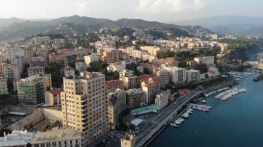 Güneşli bir yaz gününde deniz kıyısındaki güzel İtalyan şehrinin muhteşem manzarası. Evleri, caddeleri, limanları ve deniz manzaralı yatları olan bir kasaba. Savona, Liguria, İtalya