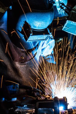 Koruyucu maskeli, kaynak yapan bir işçi.