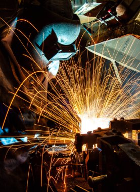 Koruyucu maskeli, kaynak yapan bir işçi.