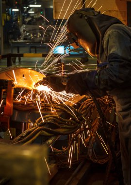 Koruyucu maskeli, kaynak yapan bir işçi.