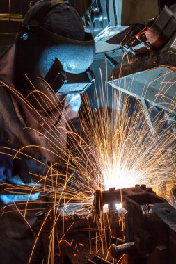 Koruyucu maskeli, kaynak yapan bir işçi.