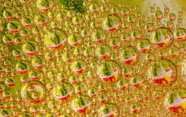 Oil drops on a water surface golder abstraction with bubbles