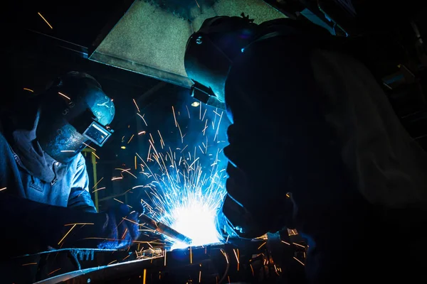The movement of workers with protective mask welding metal.