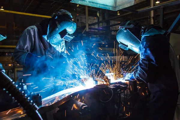 The movement of workers with protective mask welding metal.