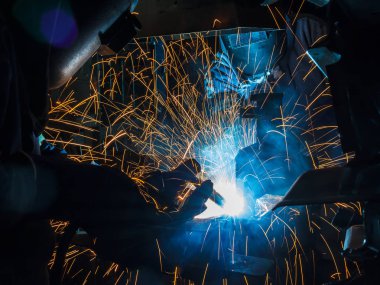 Koruyucu maskeli, kaynak yapan bir işçi.