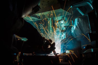 Koruyucu maskeli, kaynak yapan bir işçi.