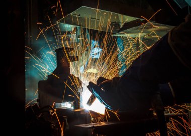 Koruyucu maskeli, kaynak yapan bir işçi.