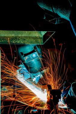 İşçi kaynak metal koruyucu maskeyle, bilgi işlem yapmaya gaz kaynak araba sanayi