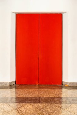 Beyaz duvardaki büyük kırmızı ahşap kapılar