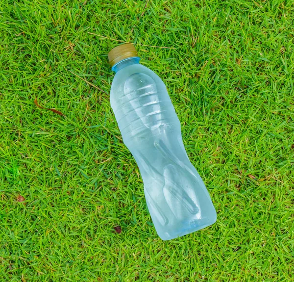 Water small bottle on green grass background