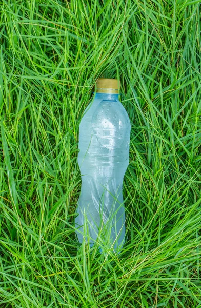 bottle of clear still water in a grass field