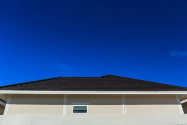 Mavi bir arka plan üzerinde koyu kahverengi kiremit çatı.