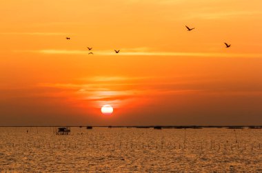 Sunset Beach, bulutlar ve deniz turuncu yansıtan güneş.