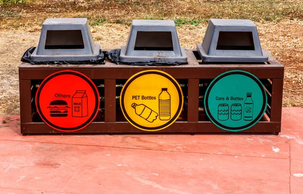 Three trash cans for recycling symbol separates the garbage intothe buckets.