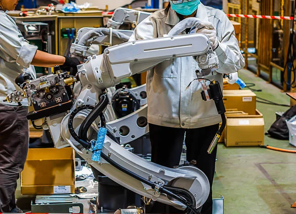 Assembly of industrial robots, People work with robots in industry.