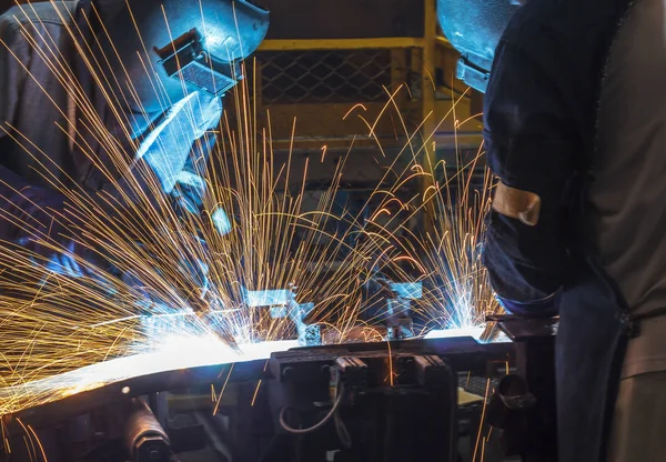 worker with protective mask welding metal