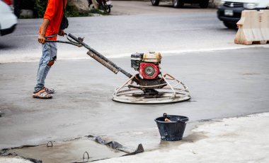 Beton zemini cilalayan işçiler.