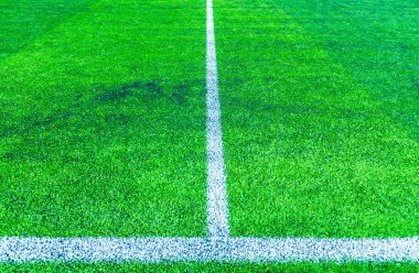 Futbol sahasının köşesindeki beyaz çizgi, yapay çimenler.