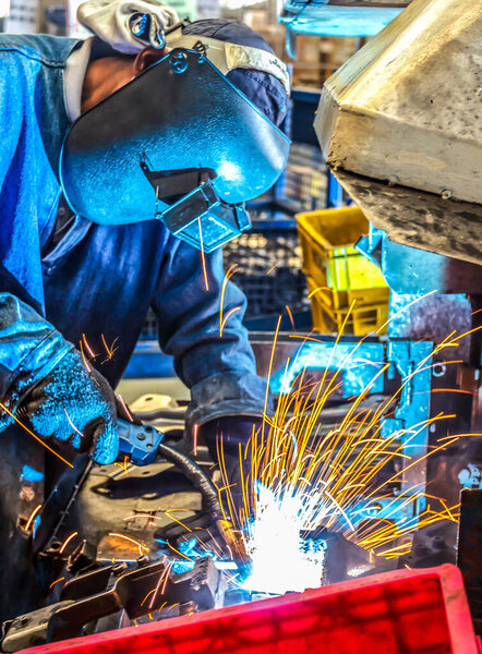 работник с защитной маски сварки металлической промышленности
