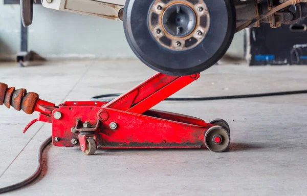 Car lift jack in the undercarriage drills — Stock Photo, Image