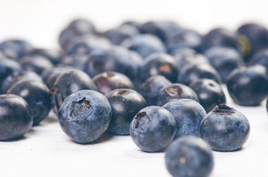 Böğürtlen, ıspanaklı ve portakallı smoothie, ahşap beyaz arka planda. Meyve ve naneli bir bardak smoothie. Böğürtlen, yaprak ve limon, masada ahududu. Meyve, sağlıklı yiyecekler. Kahvaltı..