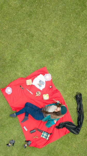 Gorgeous Latina student enjoying a picnic in the park, aerial view, available space for editing, ideal for blogs and ads