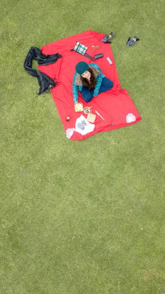 Gorgeous Latina student enjoying a picnic in the park, aerial view, available space for editing, ideal for blogs and ads