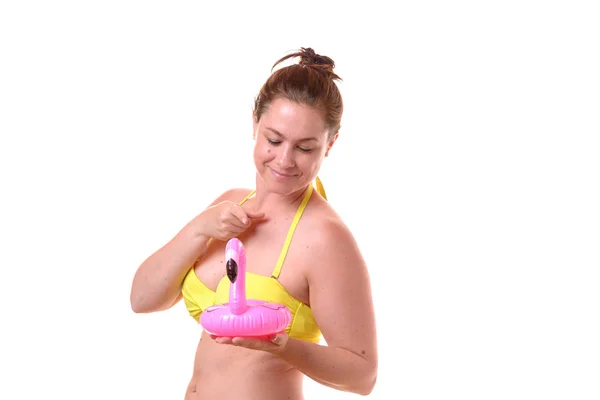 Eine Hübsche Frau Bikini Zeigt Auf Einen Rosa Aufblasbaren Flamingo — Stockfoto